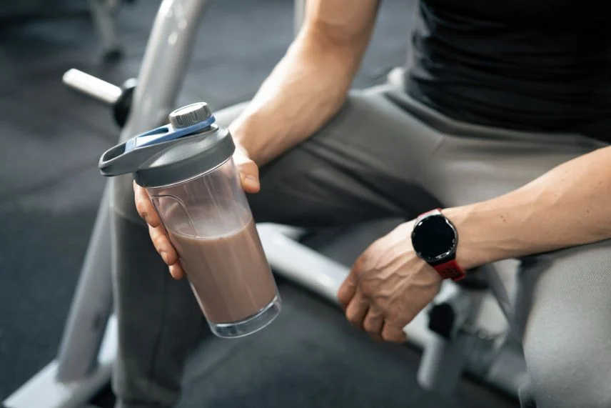 Pessoa segurando coqueteleira de proteína na academia