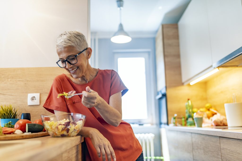 Mulher consumindo refeição saudável com salada em rotina de alimentação equilibrada
