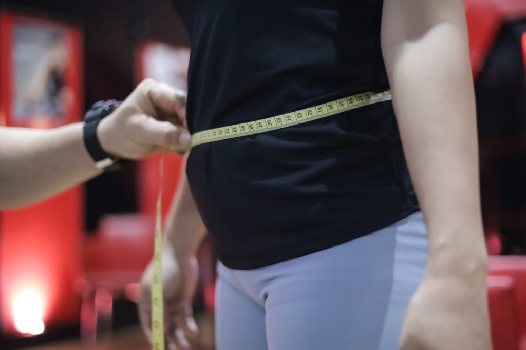 Avaliação física com fita métrica na cintura para monitorar os níveis de gordura visceral e o progresso na saúde.
