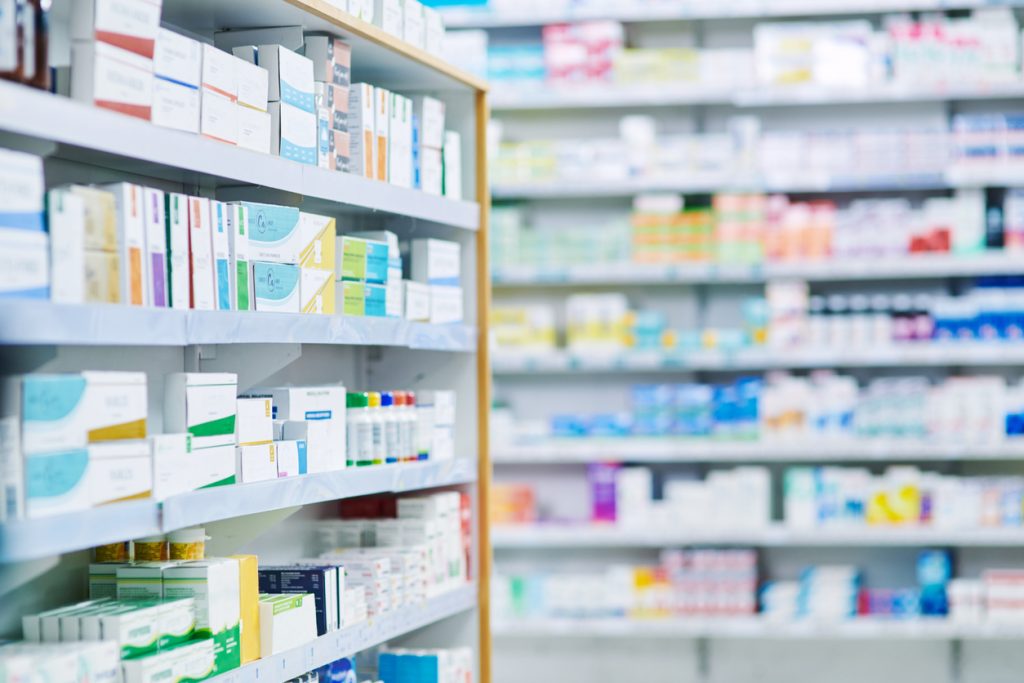 Prateleiras de farmácia com medicamentos de referência, genéricos e similares.