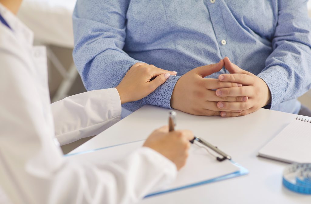Médico em consulta orientando paciente sobre tratamentos para obesidade e perda de peso sustentável.