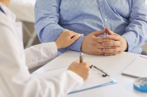 Médico em consulta orientando paciente sobre tratamentos para obesidade e perda de peso sustentável.