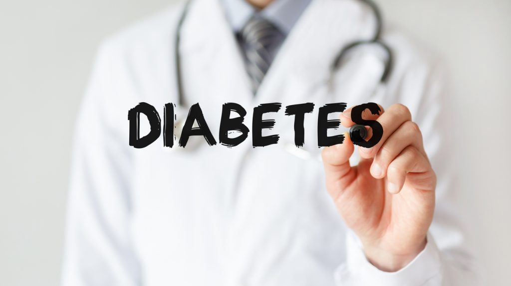 Profissional de saúde de jaleco escrevendo a palavra "diabetes", ilustrando o tema do diabetes tipo 2